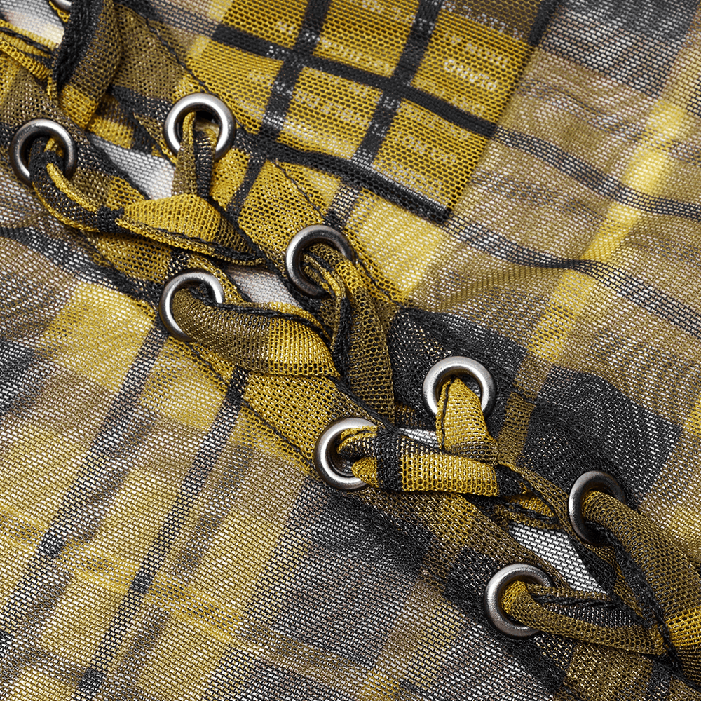 Close-up of yellow plaid mesh fabric with bold black trim and eyelets, showcasing punk-inspired design details.