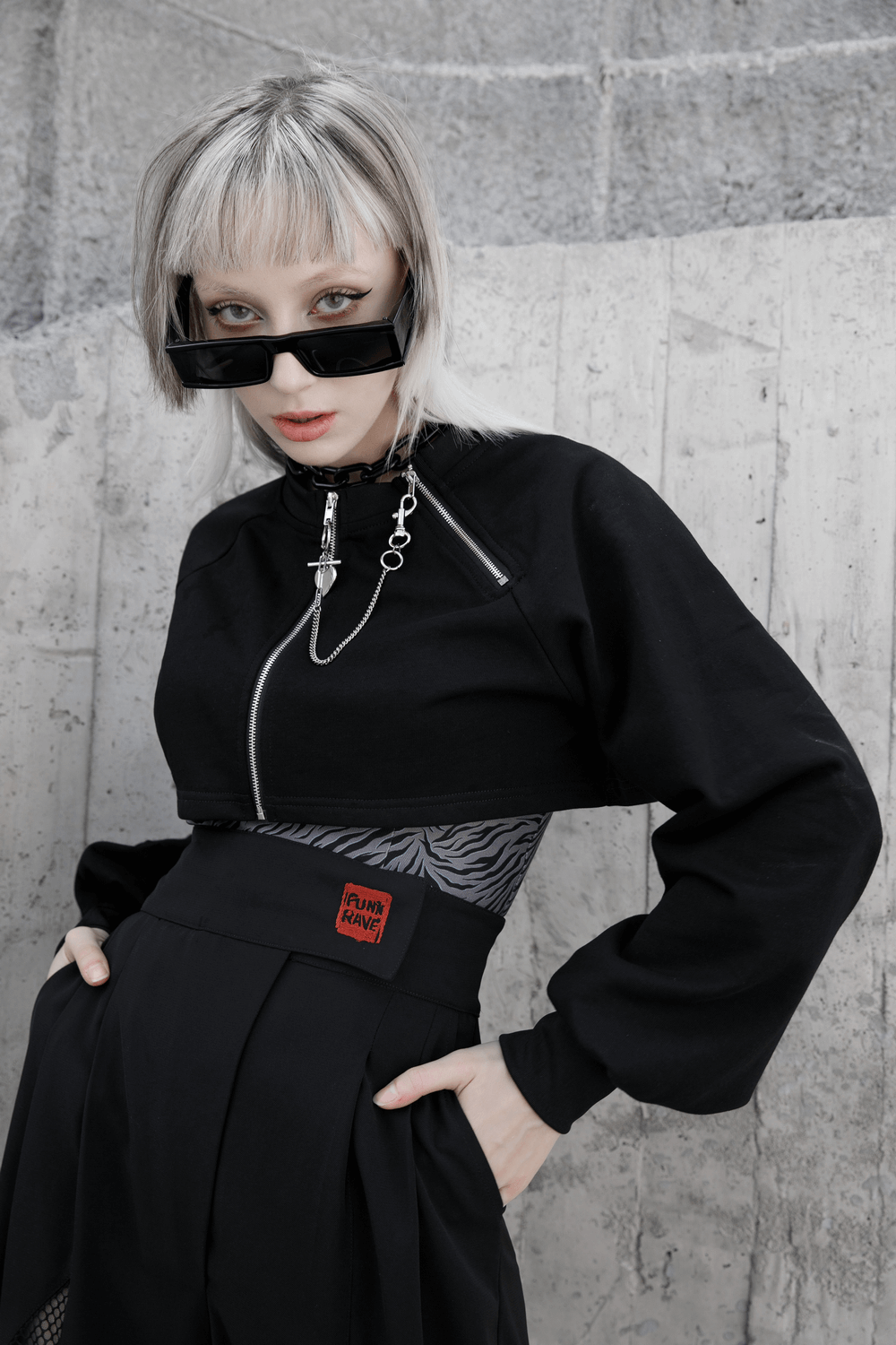 Edgy black crop jacket with long sleeves and chain detail, perfect for punk style fashion.