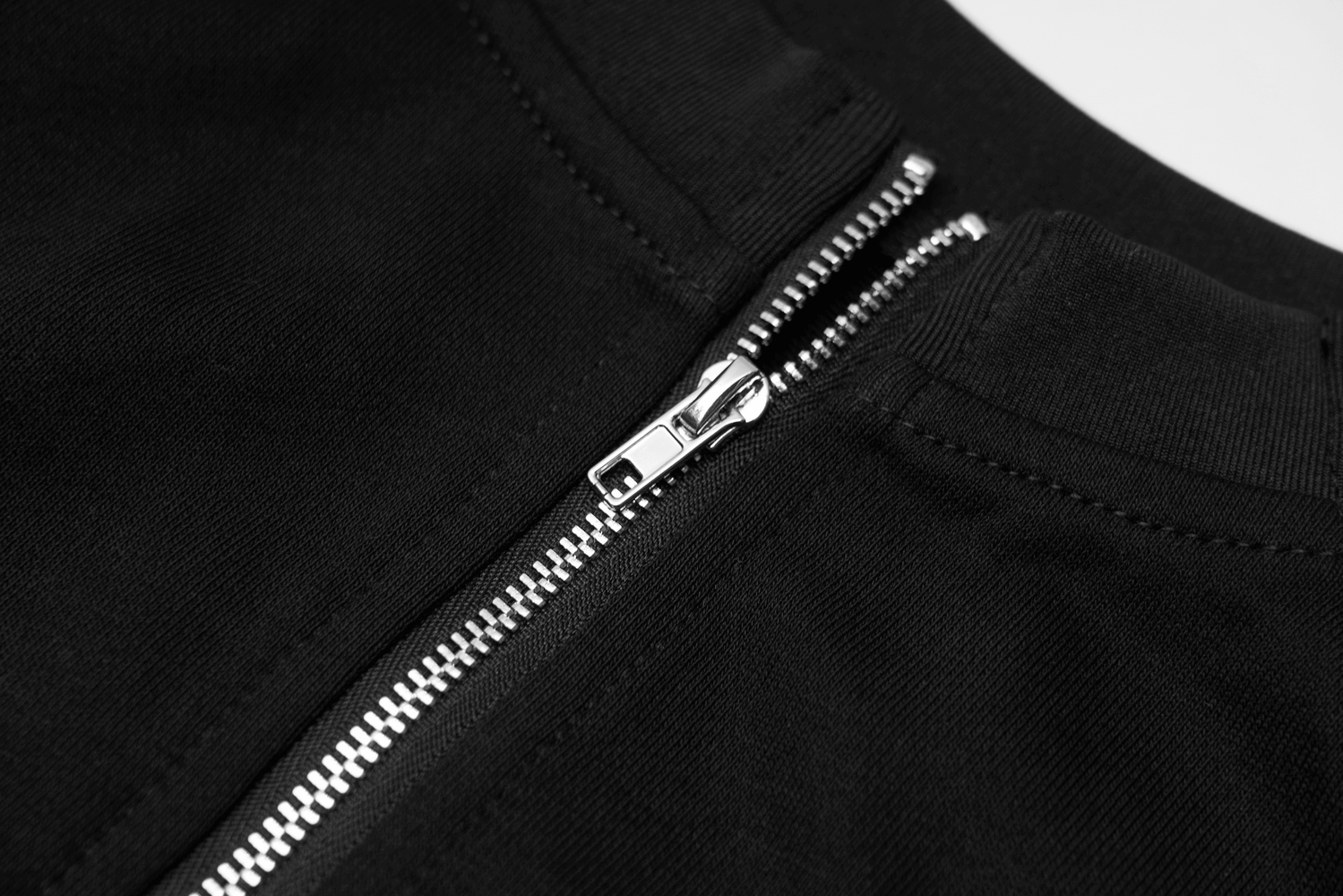 Close-up of the black zip-up detail on a crop jacket, showcasing edgy punk style and silver zipper.