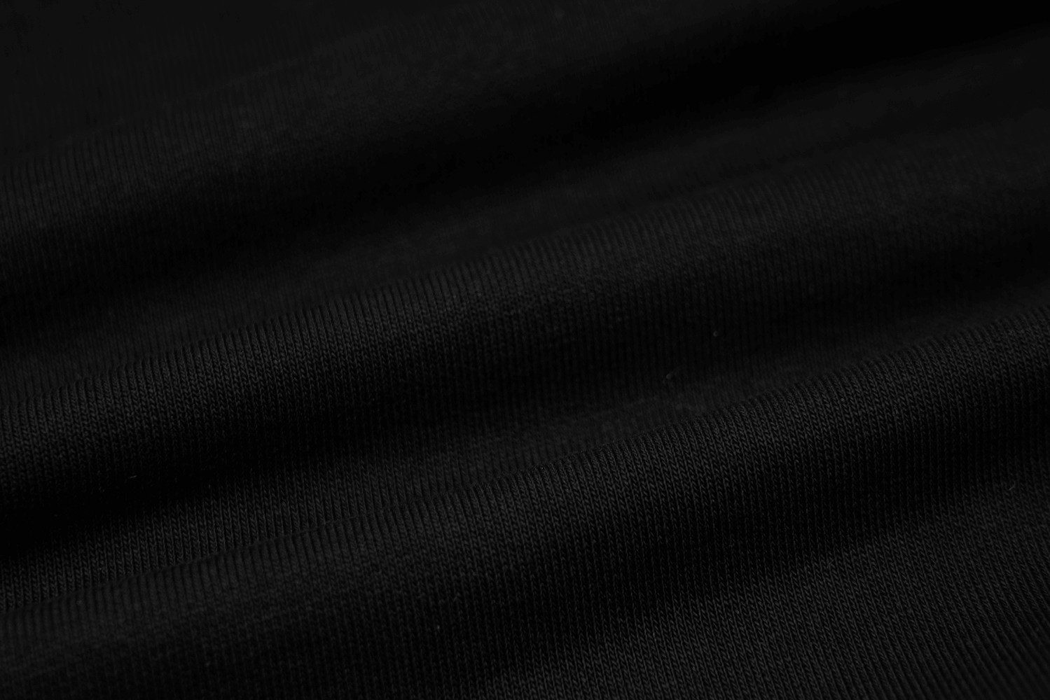 Close-up of soft, black cotton fabric perfect for a zip-up crop jacket with edgy punk style.