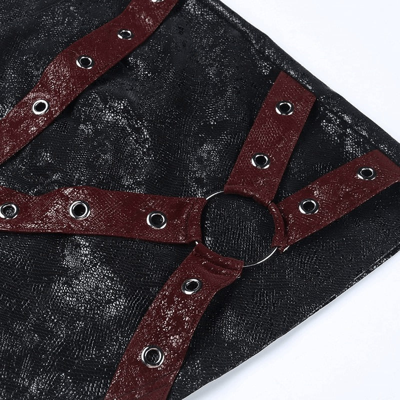 Close-up of black mini skirt with red rivet straps and rings, showcasing punk style details.
