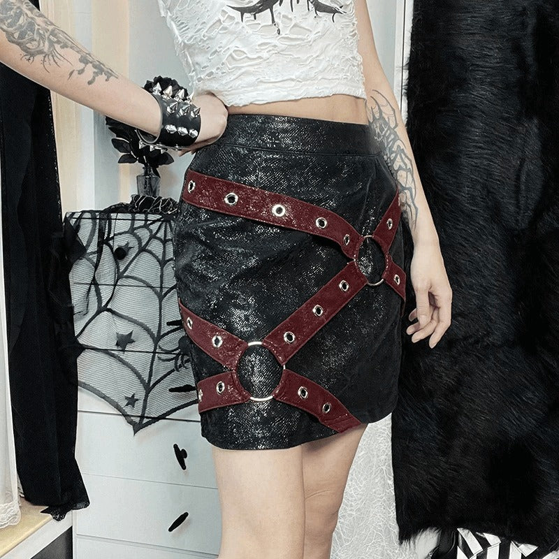 Stylish women's high-waisted mini skirt with rivet straps and rings in punk gothic fashion.