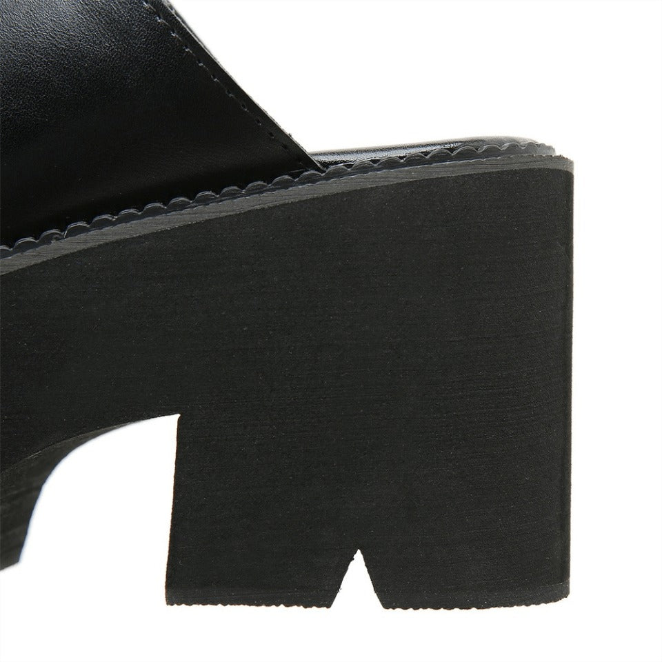 Close-up of stylish black leather platform heel for women's open-toe mules sandals, showcasing unique block design.