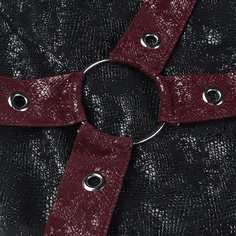 Close-up of rivet straps and rings on a black high-waisted mini skirt, showcasing stylish punk fashion details.