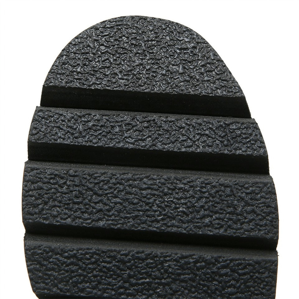 Close-up of the textured sole of black women's platform sandals showcasing a stylish gothic design.