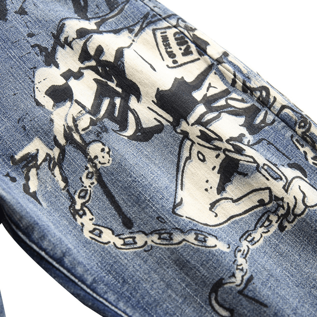 Close-up of 3D pattern denim pants featuring punk-style graphic print and chain design.
