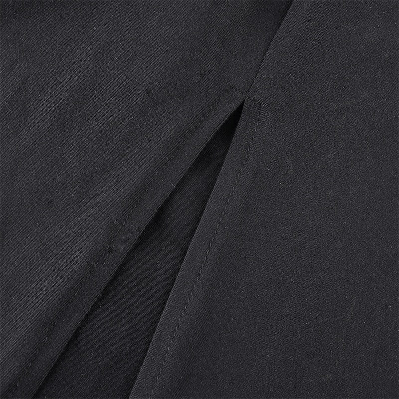 Close-up of side split detail on a black dress showcasing the fabric texture and elegant design.
