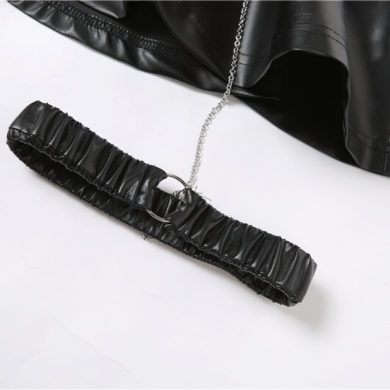 Close-up of a black faux leather mini skirt leg garter with metal chain detail for a punk rock style.