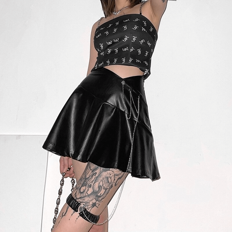 Stylish woman in black faux leather mini skirt with leg garter, showcasing punk rock fashion and vibrant tattoos.