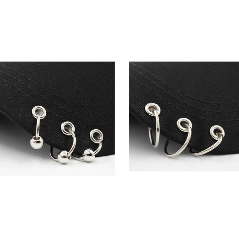 Close-up of silver ring piercings on a black adjustable baseball cap in punk style.