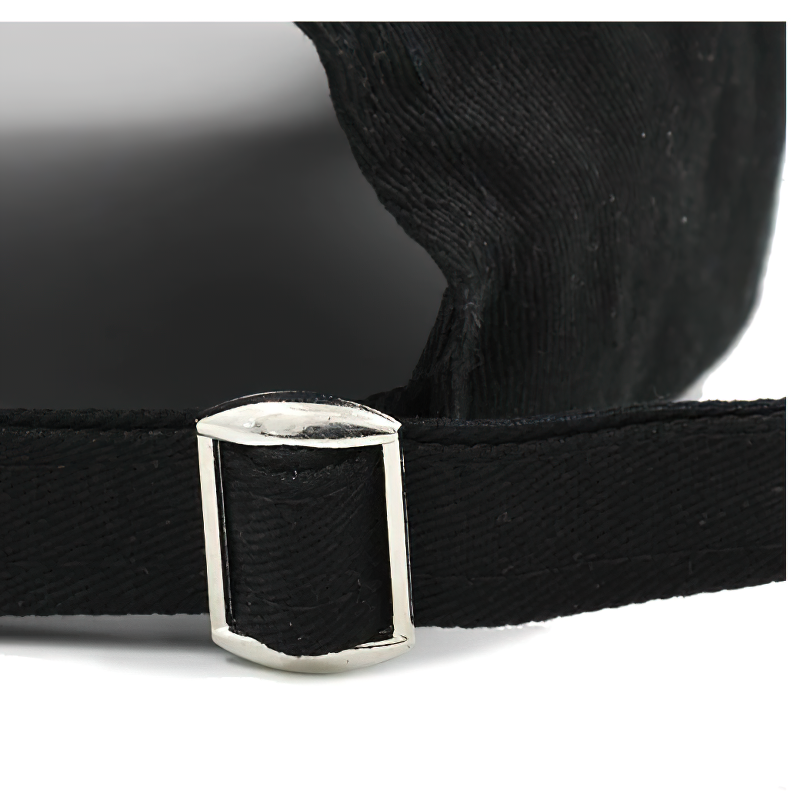 Close-up of adjustable strap detailing on black unisex baseball cap with ring piercing.