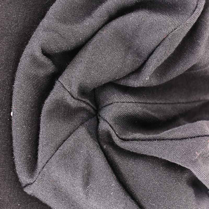 Close-up of the soft fabric structure of an adult unisex black beanie, showcasing its minimalistic and warm design.