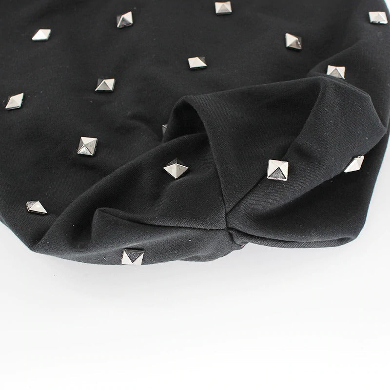 Close-up of black beanie featuring stylish metal rivets, perfect for alternative autumn and winter fashion.