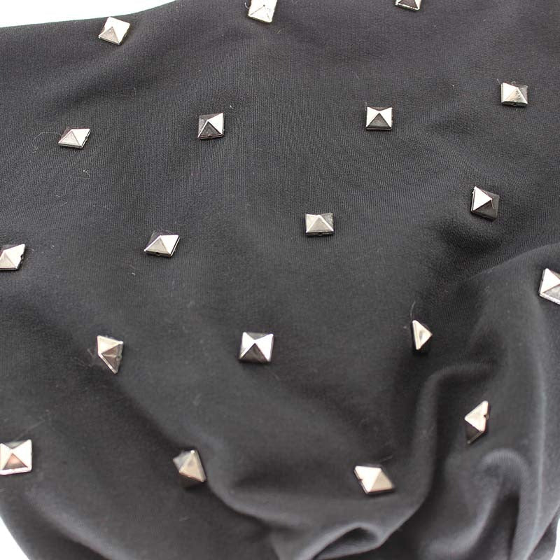 Close-up of a black beanie embellished with square metal rivets for a stylish winter accessory.