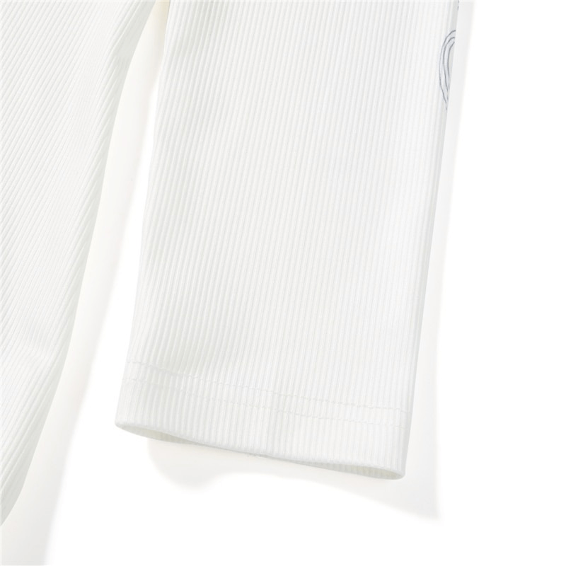 Close-up of women's long sleeve top featuring ribbed fabric and cross wings print for an aesthetic look.