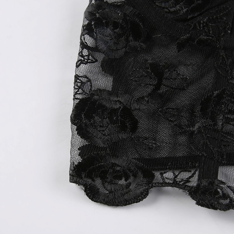 Close-up of black floral lace fabric with embroidery, showcasing delicate details for a transparent crop top.