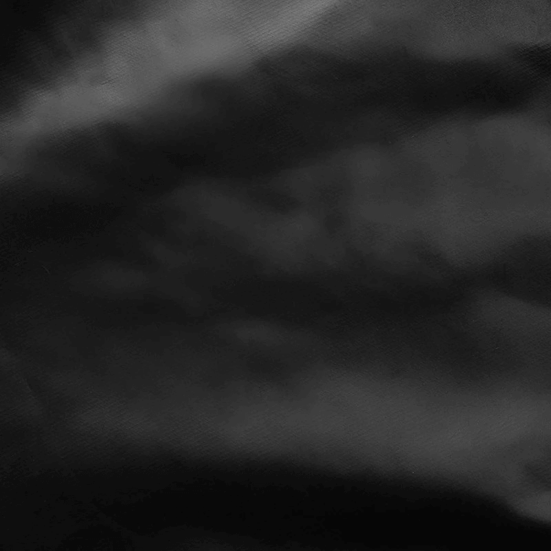 Textured black fabric background with soft, wavy patterns, ideal for fashion and design purposes.