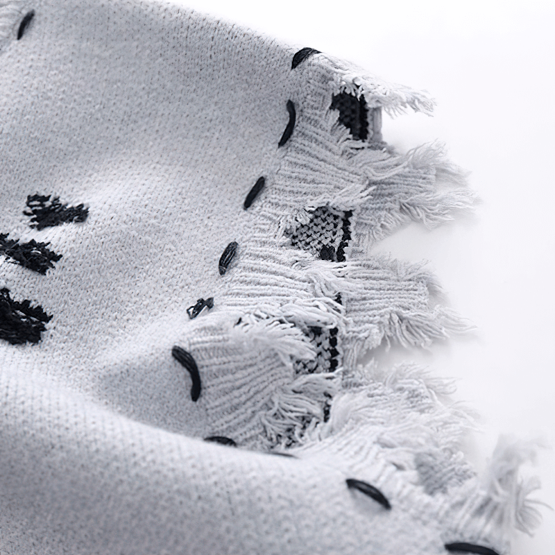 Close-up of a fringed knitted vest, showcasing the aesthetic design and textured fabric.