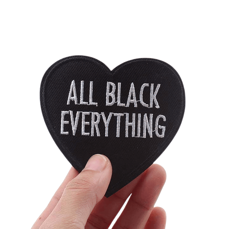 Stylish heart-shaped patch with 'All Black Everything' inscription, perfect for casual outfits and unisex fashion.