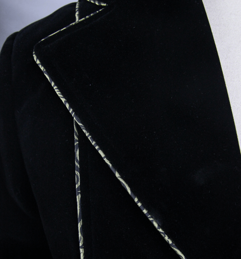 Close-up of vintage black men's coat showcasing unique golden embroidery and luxurious velvet texture.