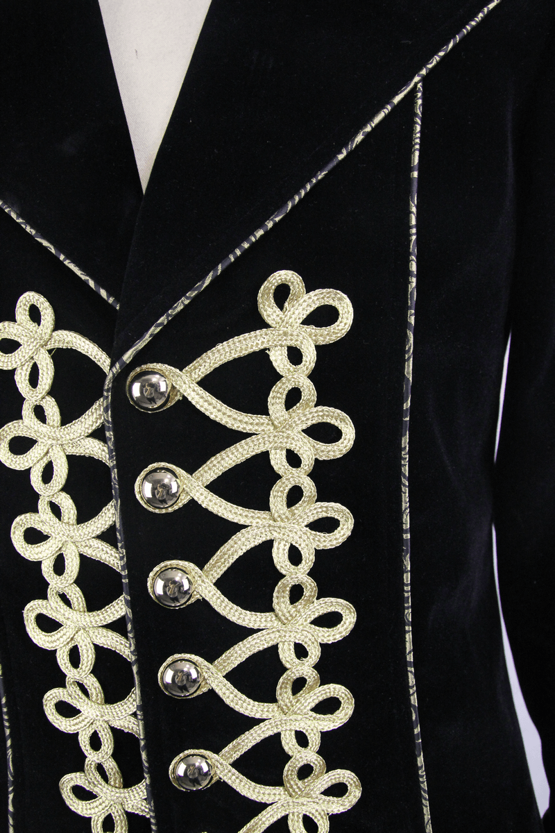 Close-up of vintage black goth coat with golden embroidery and decorative buttons.