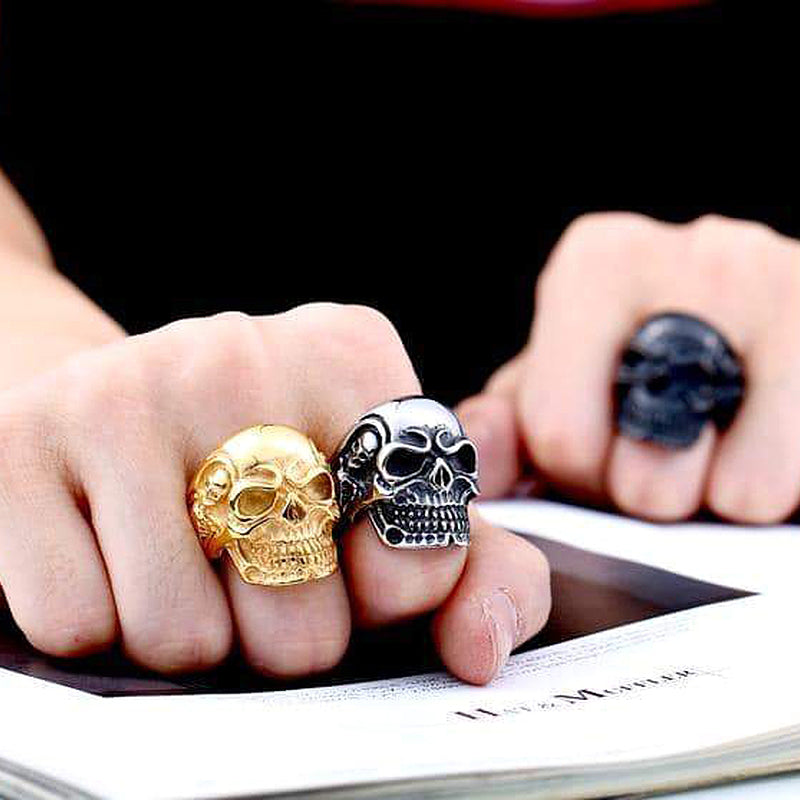 Stylish hand showcasing alternative fashion skull rings in gold and black, perfect rock style biker accessories.