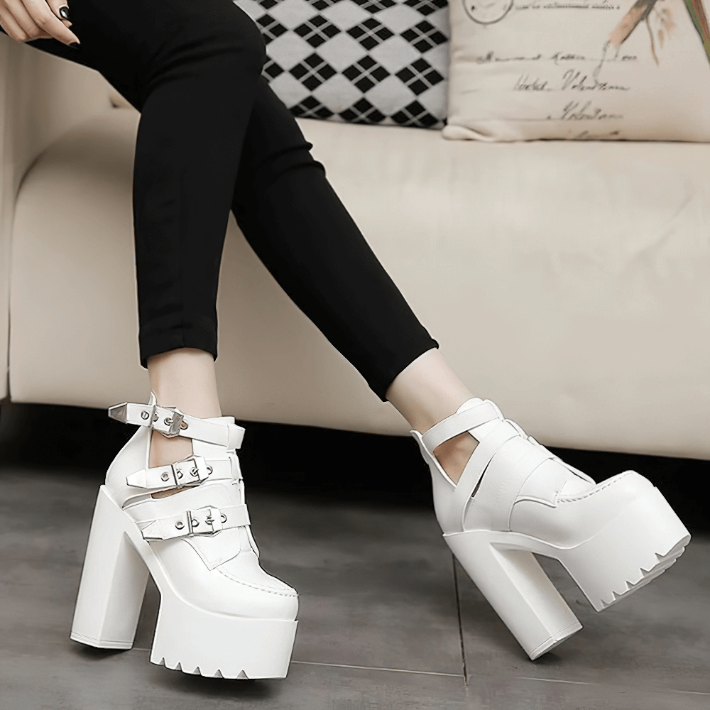 Stylish white platform ankle boots with straps and chunky heels, perfect for rocker outfits and fashion-forward looks.