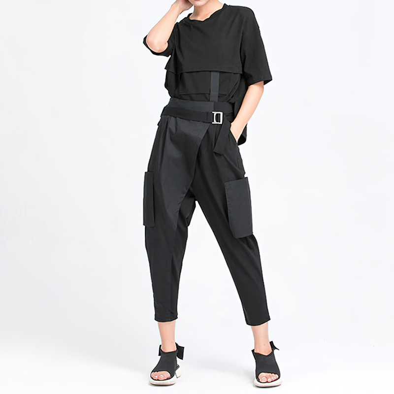 Stylish woman in cropped black top and trendy loose-fit black trousers with pockets, perfect for an alternative fashion look.