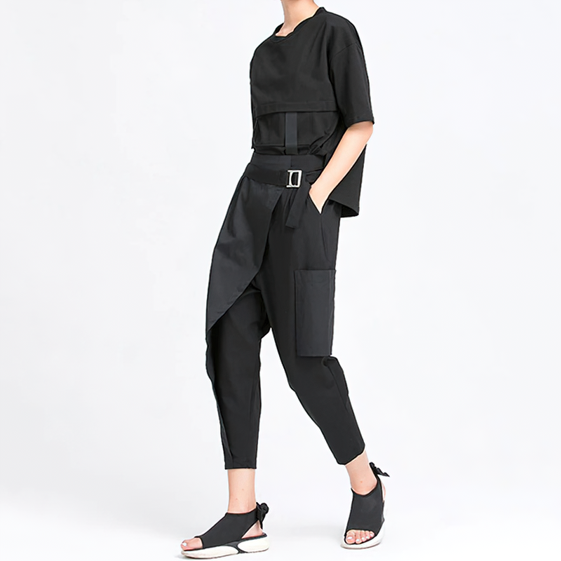 Stylish woman in alternative fashion black trousers and loose top, showing off pockets and an elastic waist.