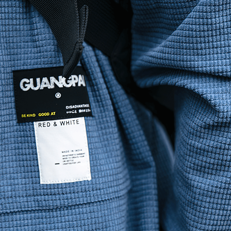Close-up of a blue waffle plaid shirt showing GUANGPAI tag and labels for alternative style clothing.