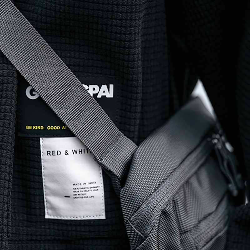 Close-up of a black waffle plaid shirt with labels featuring 'GENTLEPAI' and 'RED & WHITE' details.