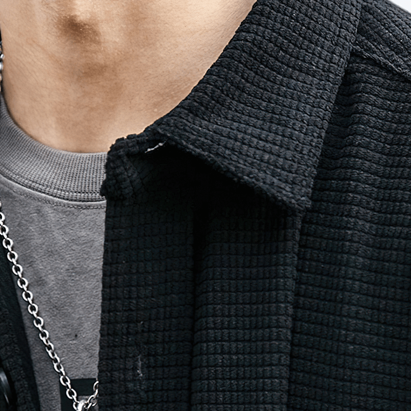 Close-up of a stylish men's black waffle plaid shirt collar, showcasing alternative fashion details.