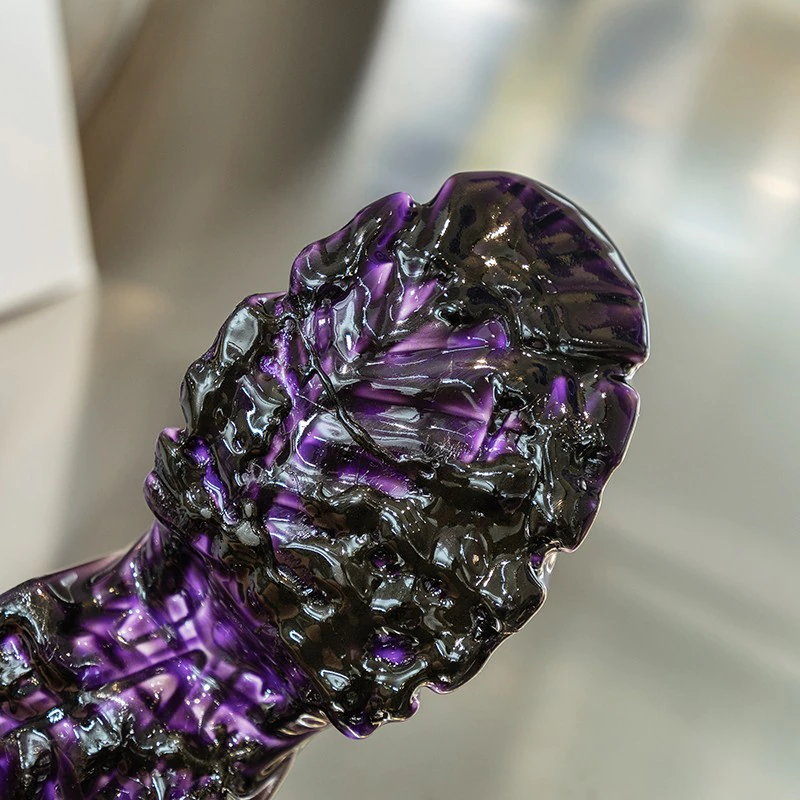 Close-up of a purple and black textured art piece showcasing intricate patterns and glossy finish.