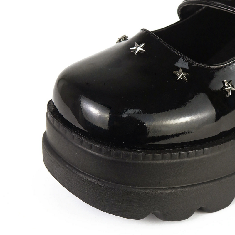 Close-up of alternative black platform pumps with star embellishments, perfect for gothic fashion and high-style outfits.