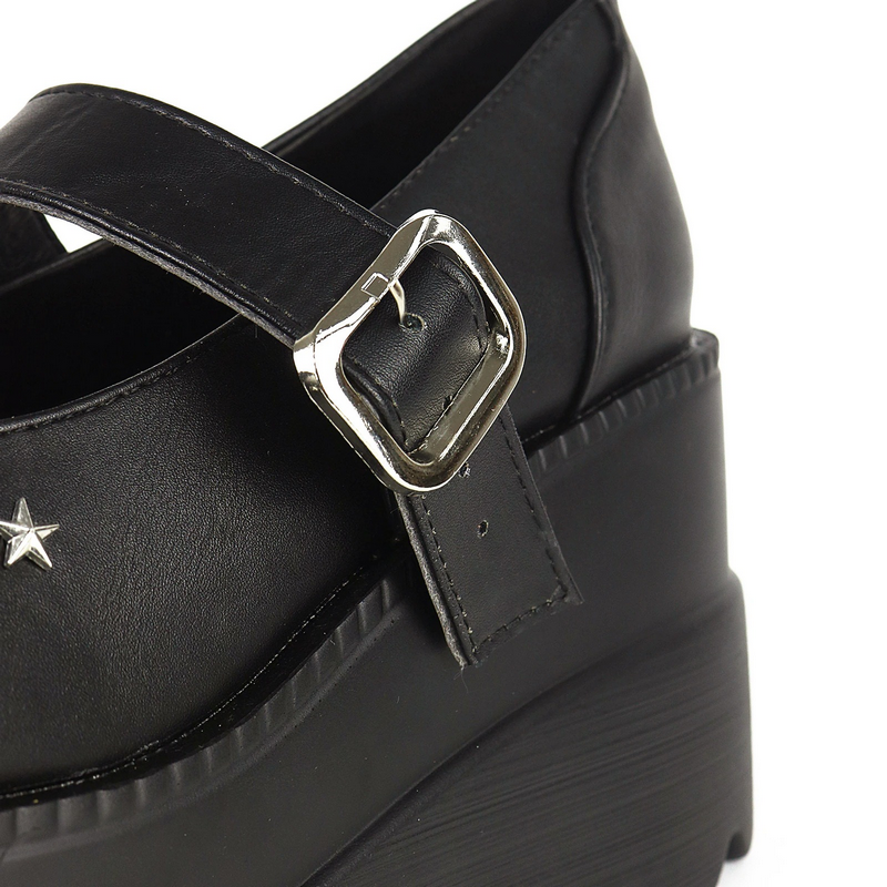 Close-up of black platform leather pumps featuring a stylish buckle and star detail, perfect for gothic outfits.