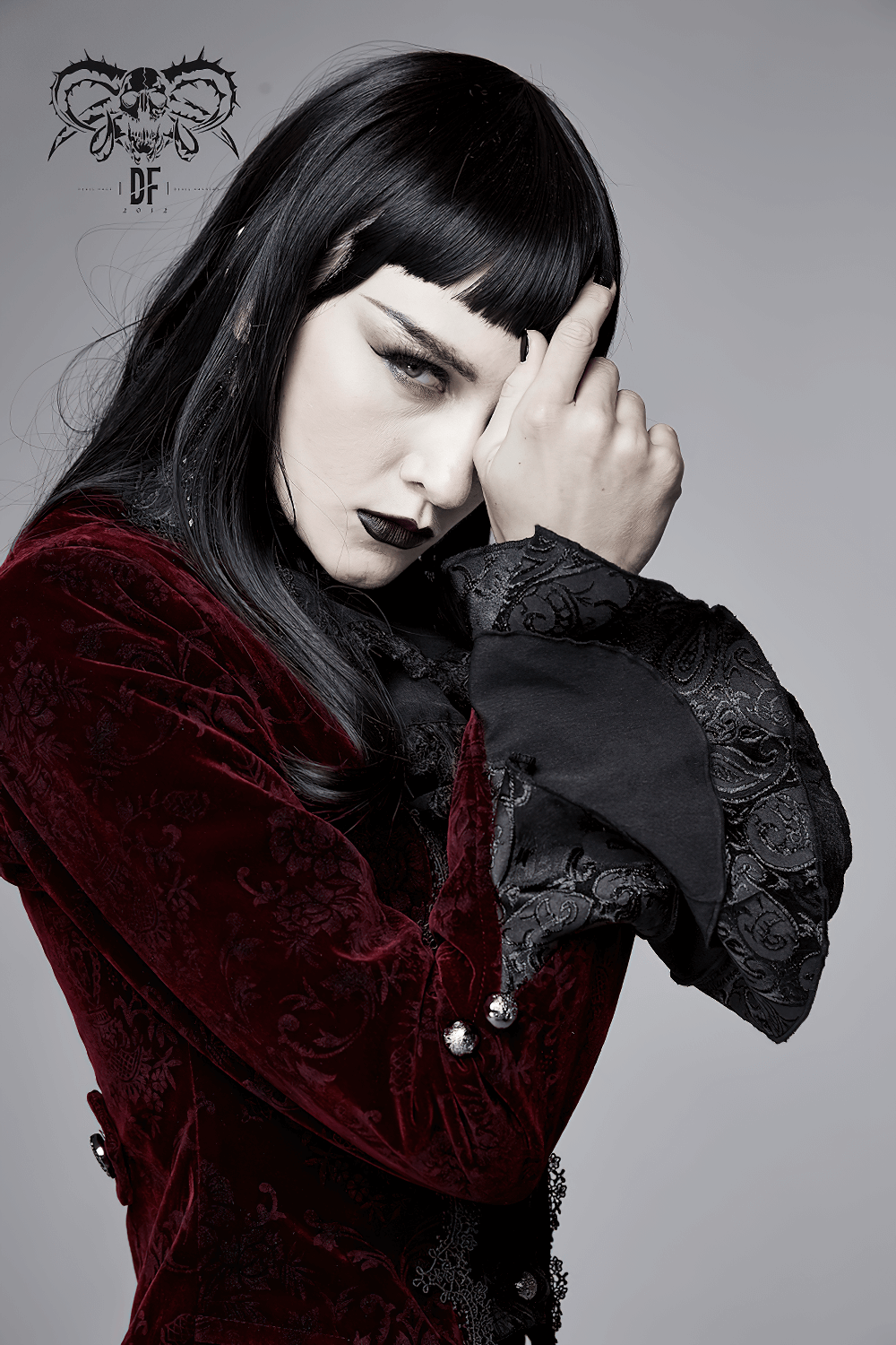 Gothic model in a wine red puff sleeved jacket, showcasing elegant vintage style and luxurious velvet fabric.