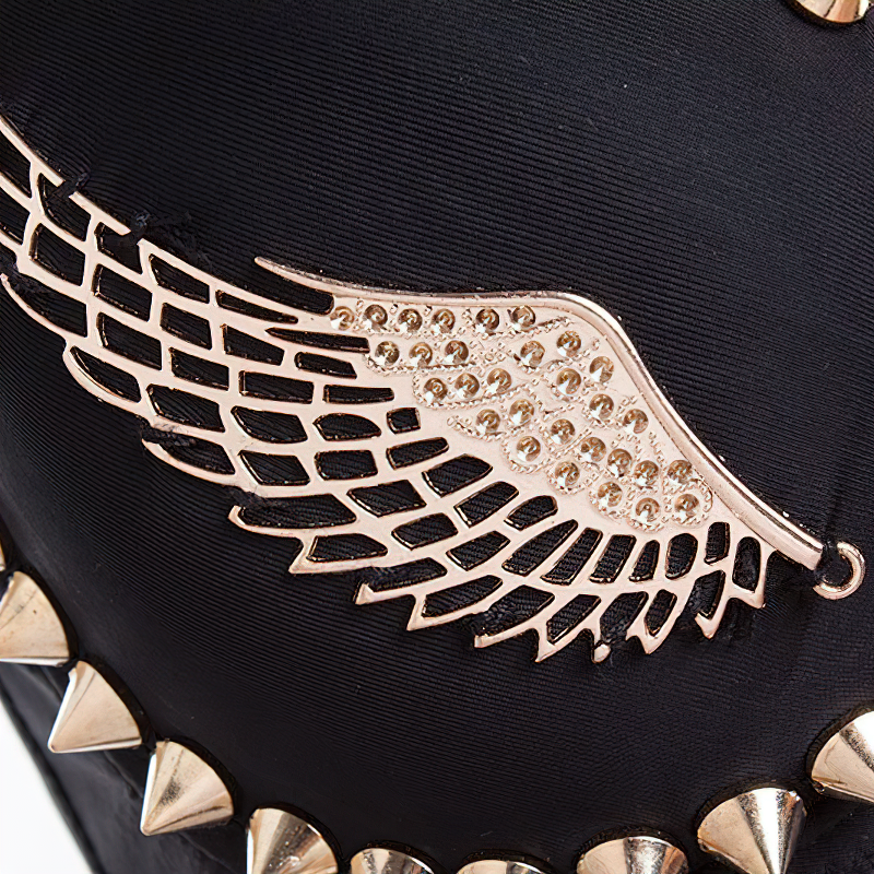 Close-up of angel wing detail on spiked black bra, adorned with golden rivets for a rock-style vibe.