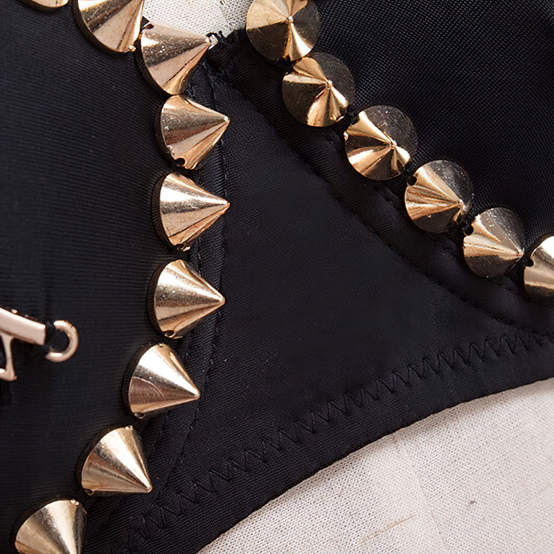 Close-up of black bra with stylish golden spike rivets, showcasing rock style and edgy design.