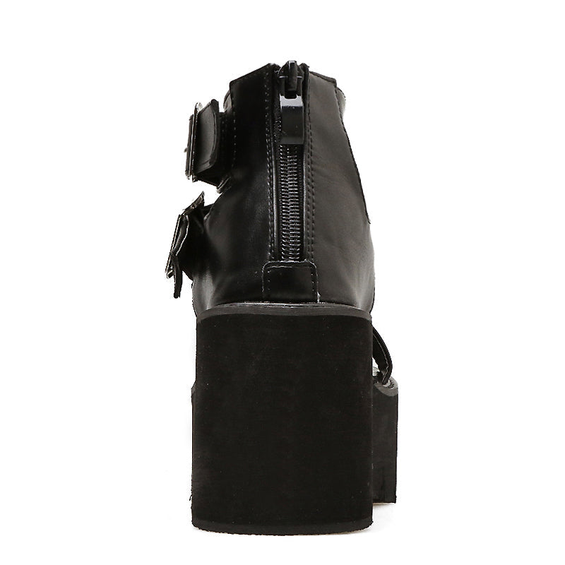 Side view of women's ankle strap platform sandals with thick heels in black faux leather, featuring a stylish zipper detail.