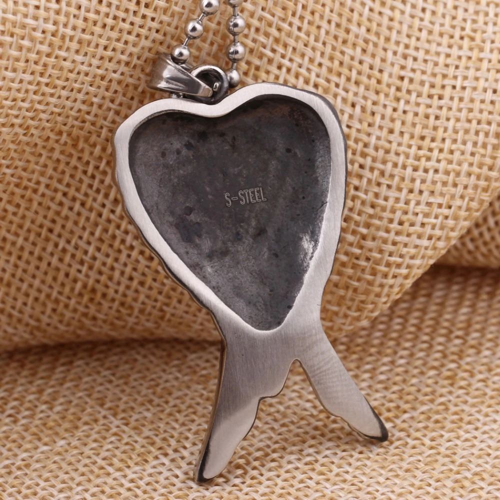 Antique stainless steel heart-shaped pendant necklace with unique design on textured background.