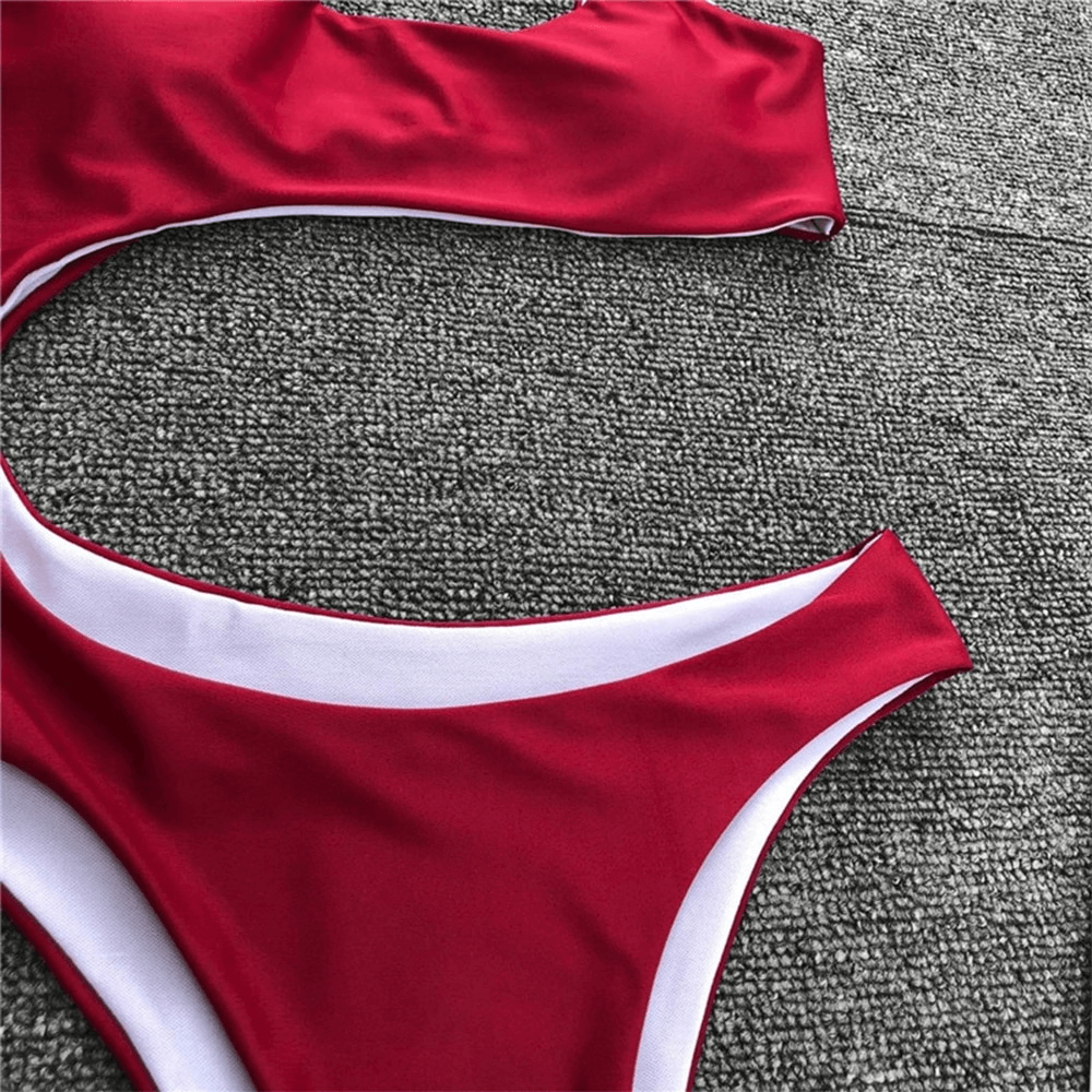 Close-up of a women's asymmetrical red bikini, showcasing stylish design and contrast trim details.