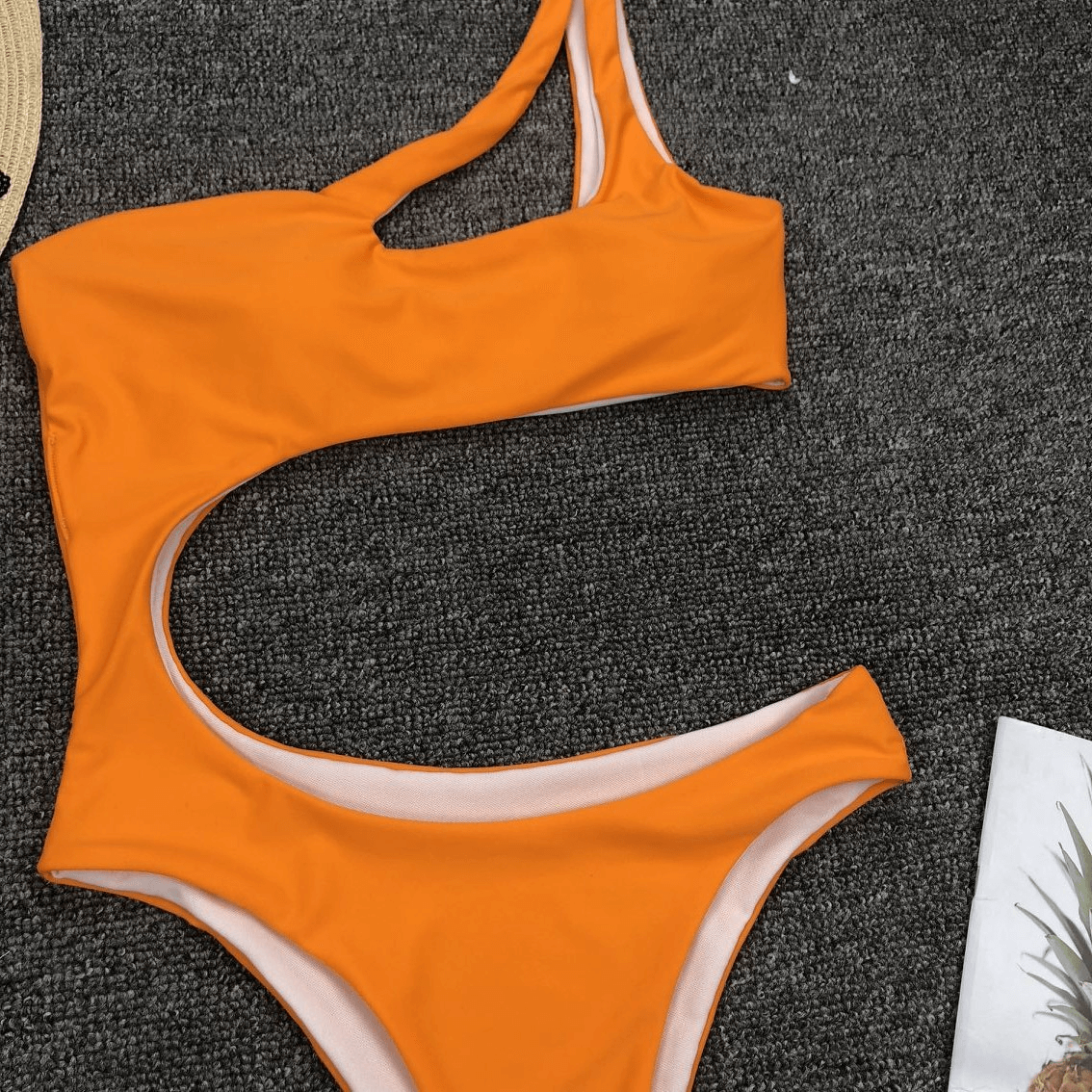 Stylish women's asymmetrical one piece swimsuit in vibrant orange, perfect for summer beach outings.