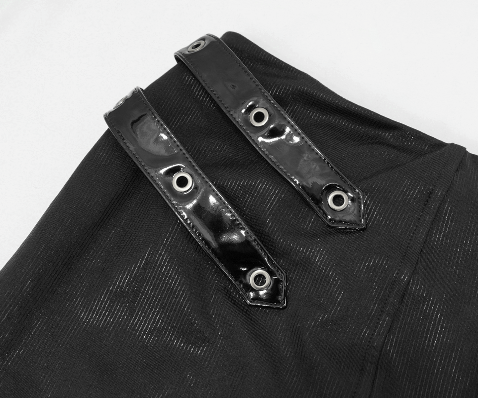 Close-up of black mini skirt with shiny buckles and rivets, showcasing gothic style and edgy fashion details.