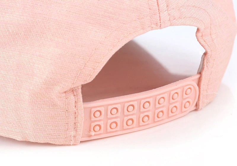 Close-up of a unisex pink baseball cap with adjustable snapback and breathable cotton fabric, perfect for rave outfits.