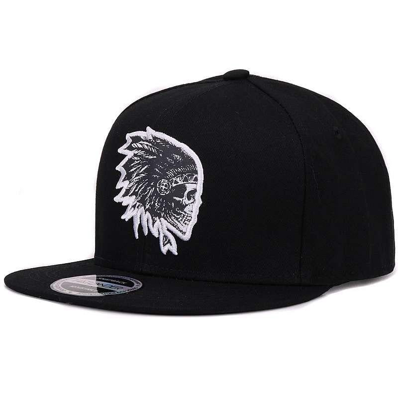Black snapback cap with embroidered skull and feather design for a stylish rock look.