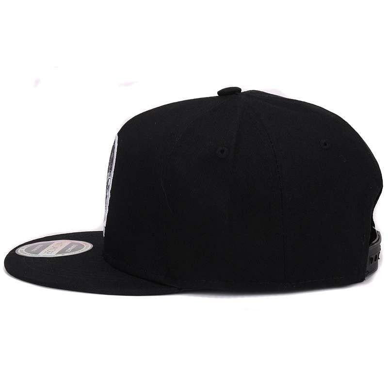 Black snapback baseball cap with embroidered skull, showcasing sleek style and adjustable fit, perfect for any outfit.