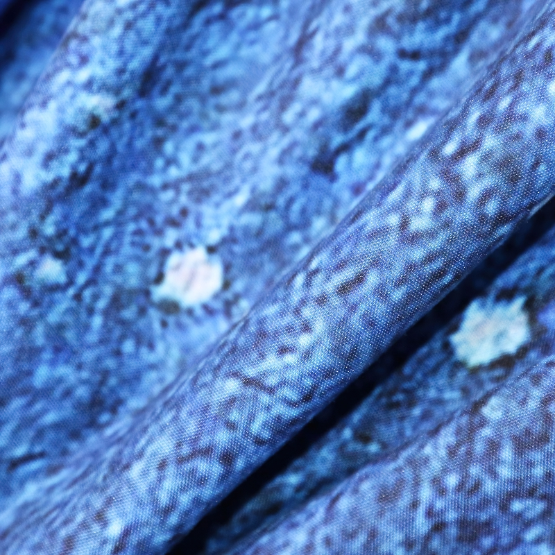 Close-up of blue fabric featuring a stylish feather print, perfect for a gothic-themed bedding set.