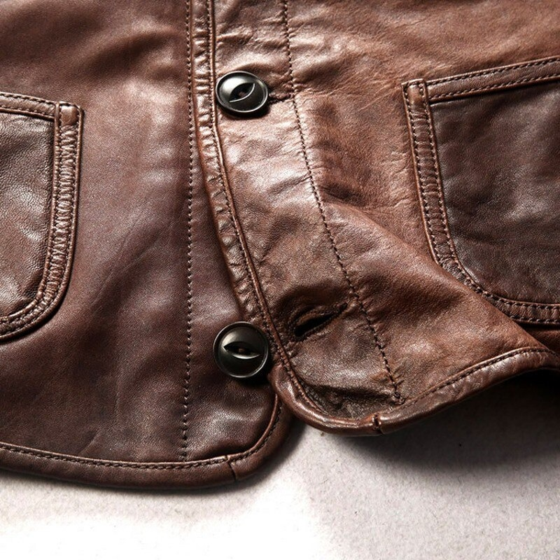 Close-up of a brown genuine leather biker vest showing buttons and pockets, perfect for alternative fashion.