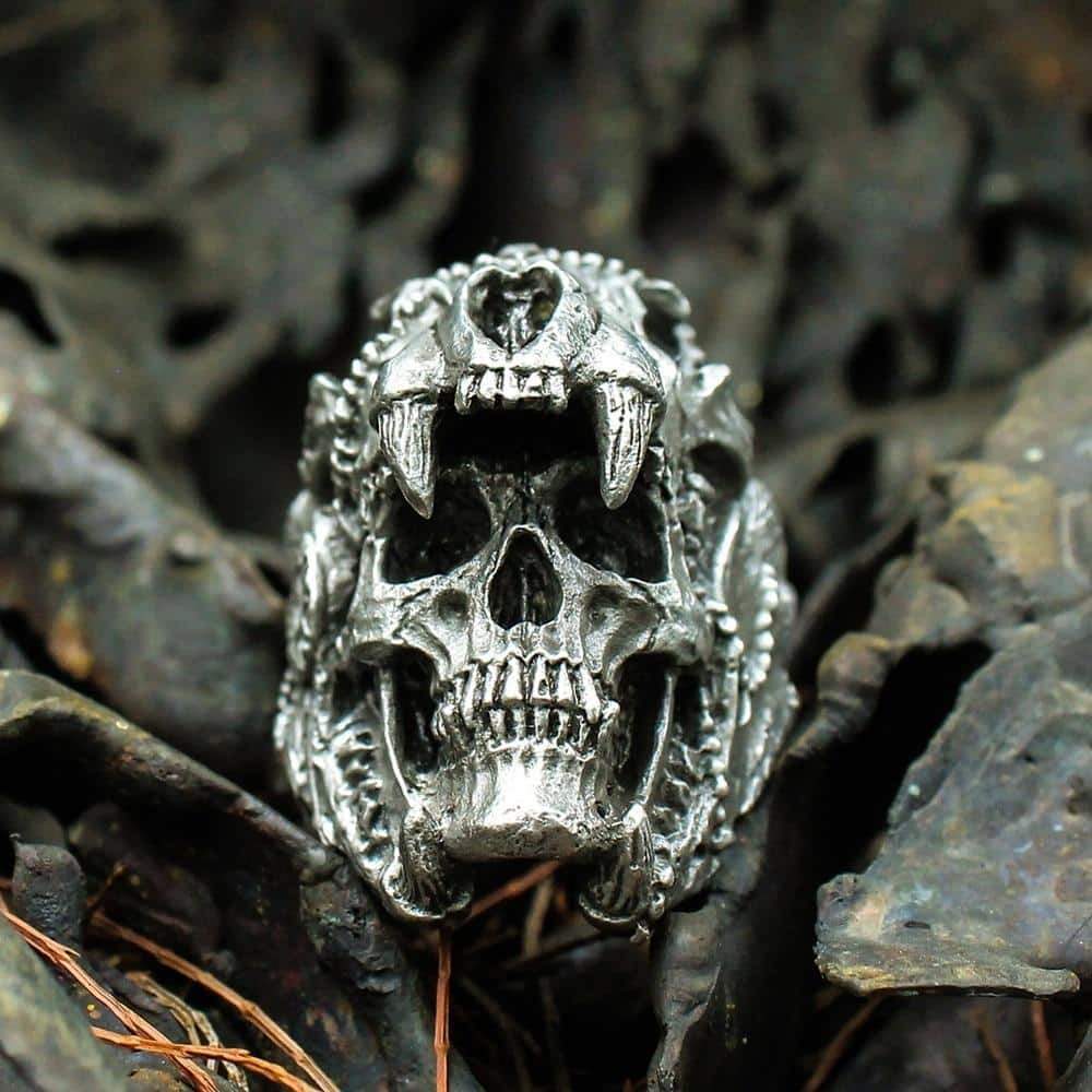 Intricately designed stainless steel skull ring on dark foliage, perfect for rock style and cosplay enthusiasts.