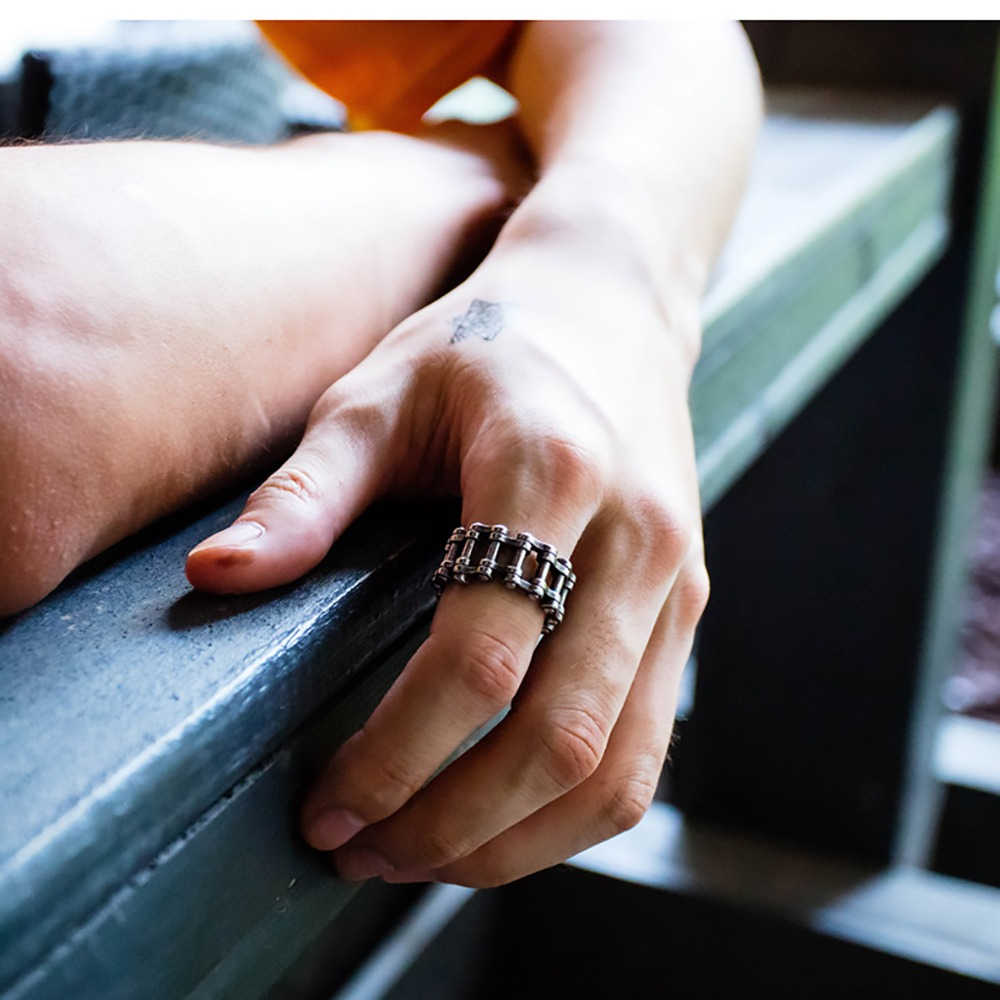 Hand wearing a stainless steel biker chain ring, showcasing punk rock style for unisex fashion.